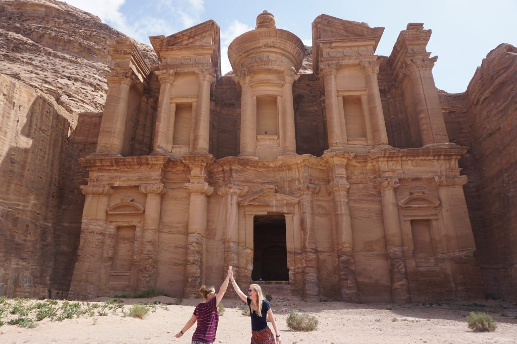 high fiving a friend after surviving the hike to the Monastery in Petra, Jordan