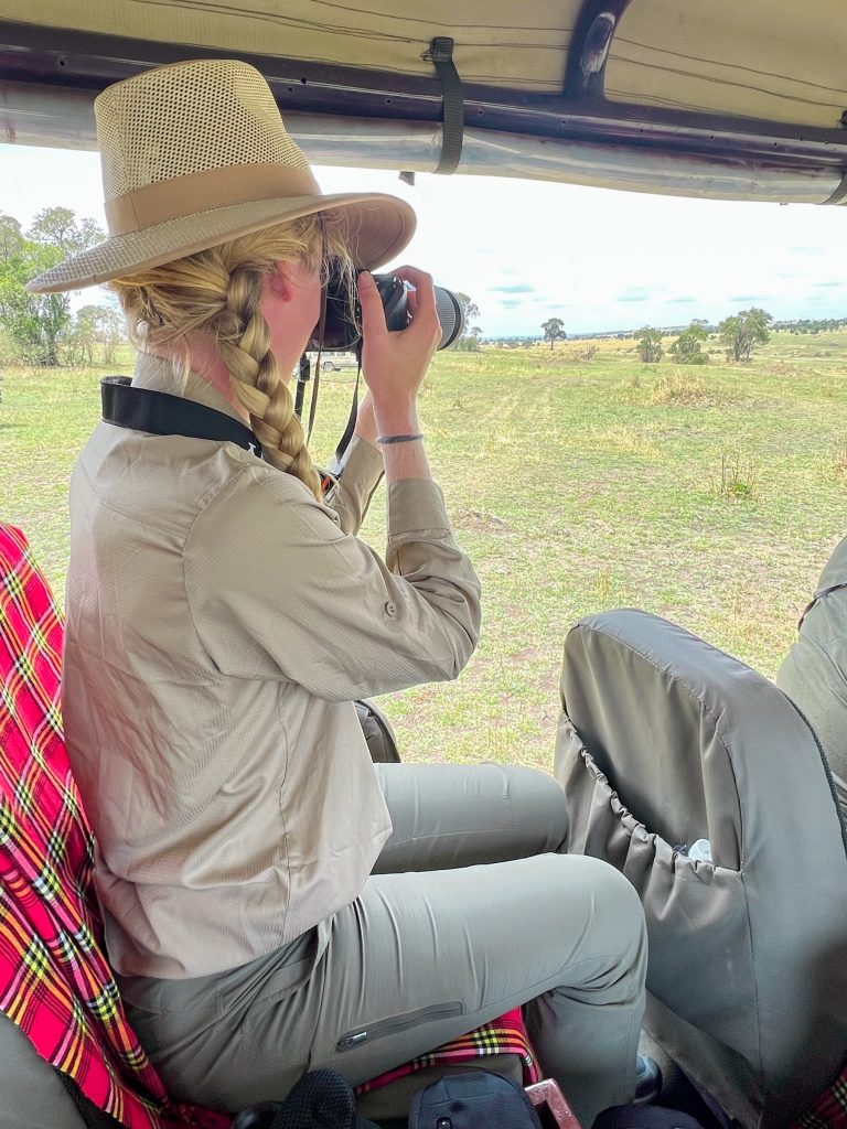 What to wear on safari for women: olive green pants, khaki shirt, and sun hat. 