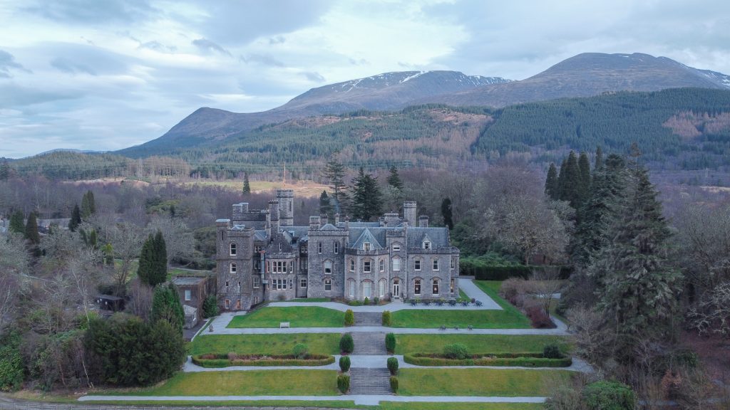 drone view of Inverlochy Castle Hotel in Fort William, Scotland with Ben Nevis Mountain in the background